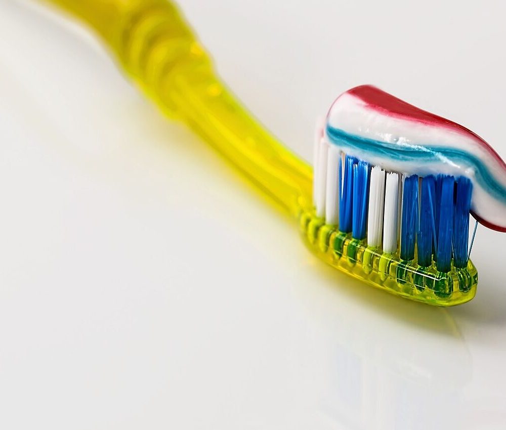 Toothpaste being squeezed onto a toothbrush