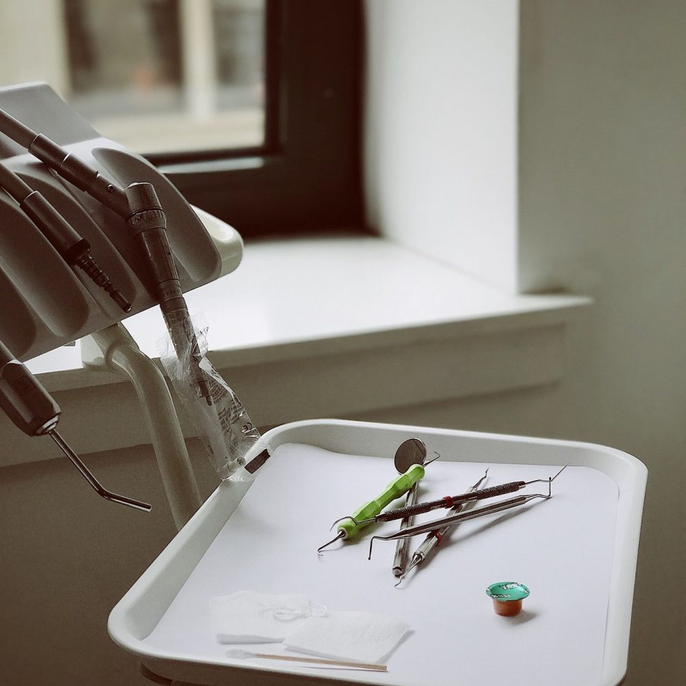Dental instruments laid out on a tray beside a window